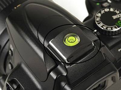 There is a canon camera with a yellow glass circular bubble level vial in it.